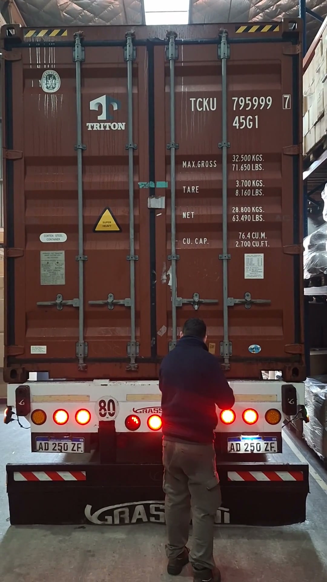 Operario frente a la puerta abierta de un contenedor sobre un camión, al inicio de la descarga de SHIMANO